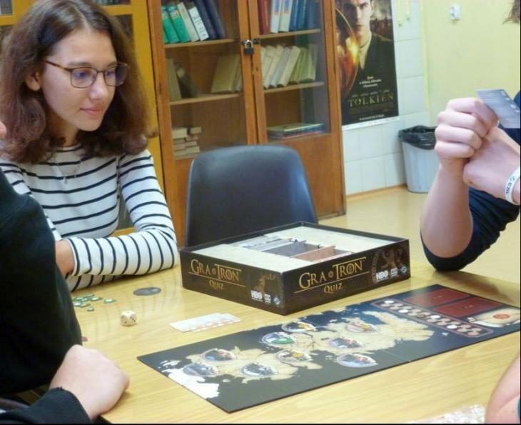 Na zdjęciu troje uczniów podczas rozgrywek inspirowanych serialem "Gra o tron". Rogrywka miała formę gry planszowej i odbyła się w szkolnej czytelni.