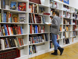 dziewczyna przed półkami z książkami