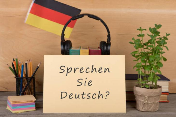 Kartka z napisem Sprechen Sie Deutsch na tle niemieckiej flagi