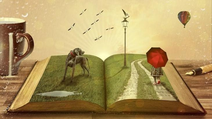 Na otwartej książce widać psa, dziewczynkę z czerwonym parasolem i lecącego ptaka