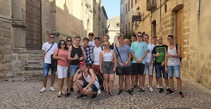 Uśmiechnięta grupa uczniów ZSB-C wraz z opiekunami na uroczej uliczce Ubedy