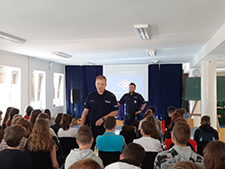 Uczniowie słuchają wykładu policjantów o odpowiedzialności karnej