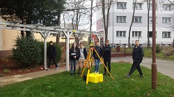 uczniowie w czasie warsztatów geodezyjnych przed szkoła