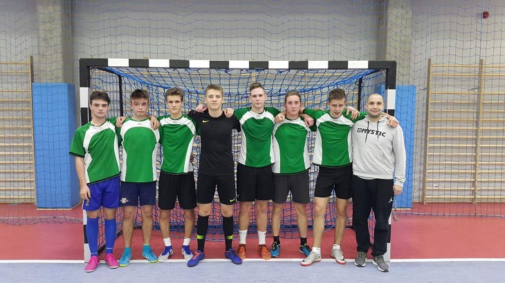 zawodnicy pozują na tle bramki