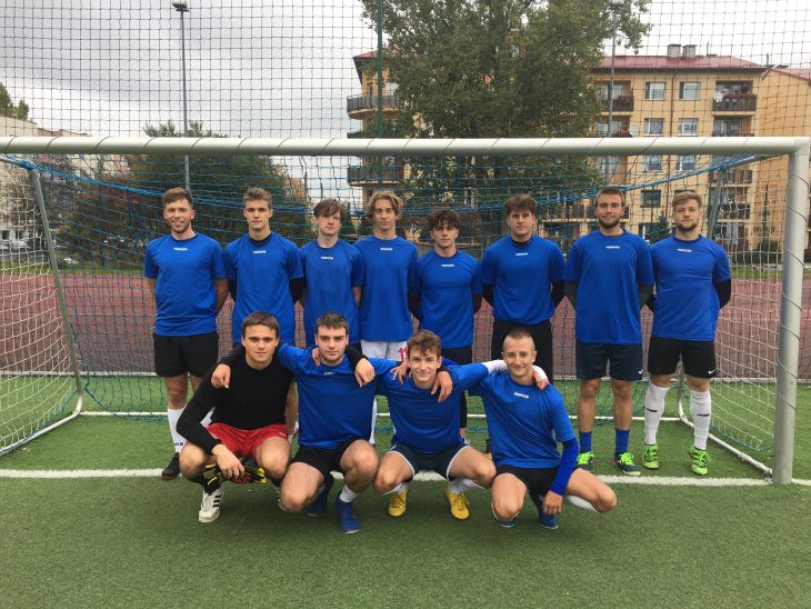 reprezentacja szkoły w piłce nożnej w niebieskich strojach na tle bramki