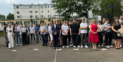 Nauczyciele oraz uczniowie na boisku szkolnym podczas uroczystości zakończenia roku szkolnego