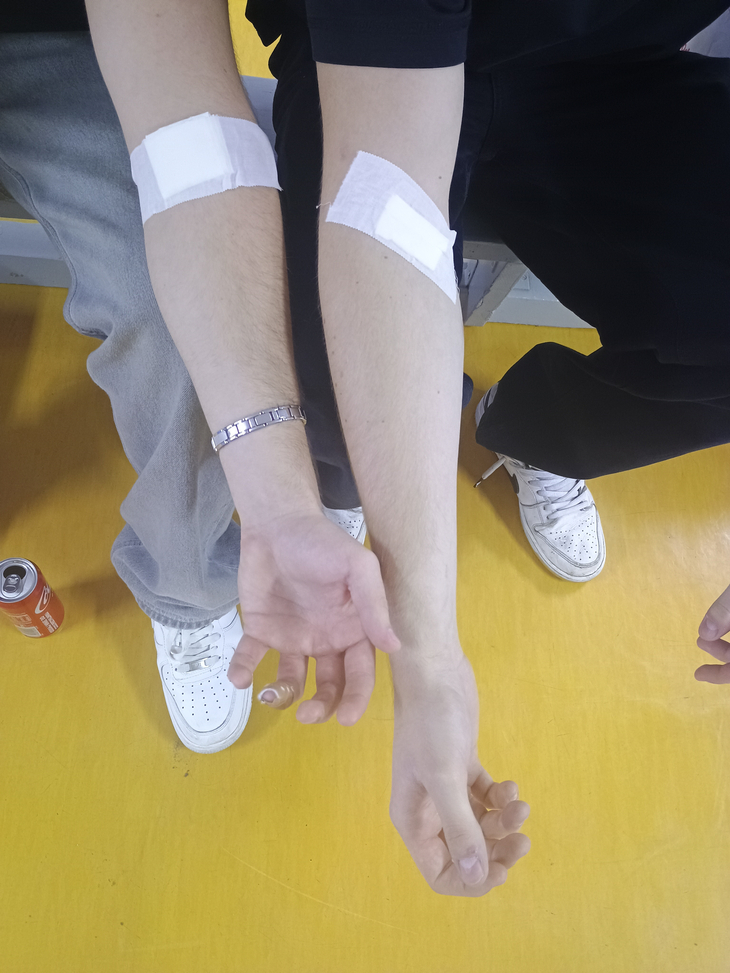 uczniowie po oddaniu krwi z rękami zaklejonymi plastrem