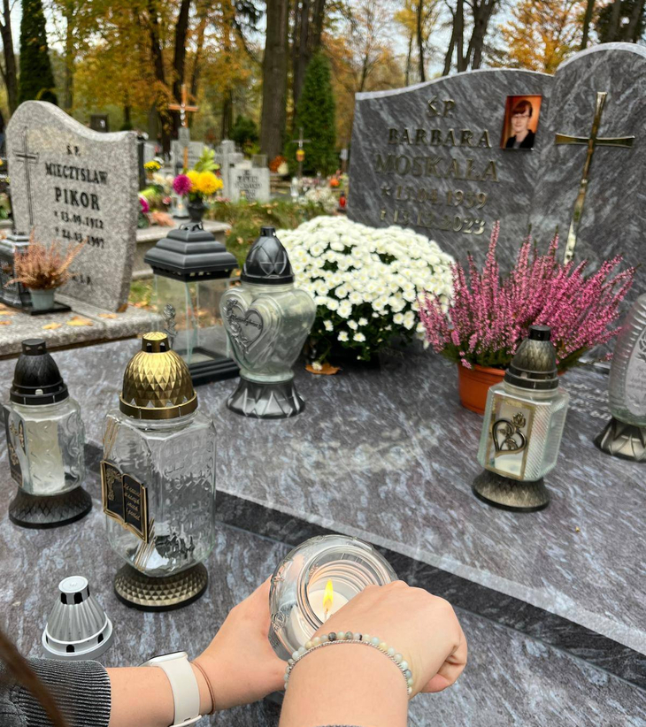 ręce uczennicy zapalającej znicz na grobie jednej z nauczycielek