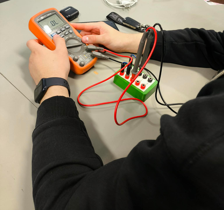 Na zdjęciu uczestnik szkolenia SEP wykonuje pomiar parametrów elektrycznych przy użyciu miernika uniwersalnego.